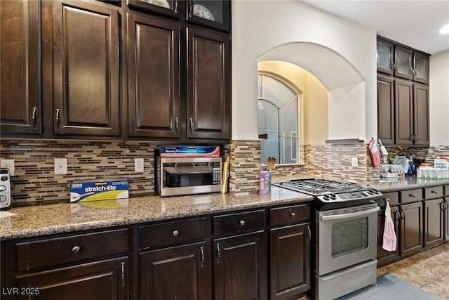 6714 Flamenco Ct, Las Vegas, NV 89139 - kitchen with stainless steel appliances, tasteful backsplash, light stone counters, dark brown cabinets, and recessed lighting