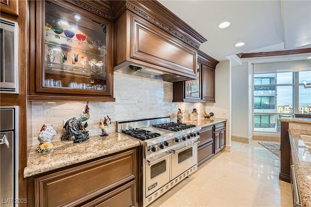9103 Alta Dr Unit 407, Las Vegas, NV 89145 - kitchen featuring range with two ovens, tasteful backsplash, light stone countertops, glass insert cabinets, and recessed lighting