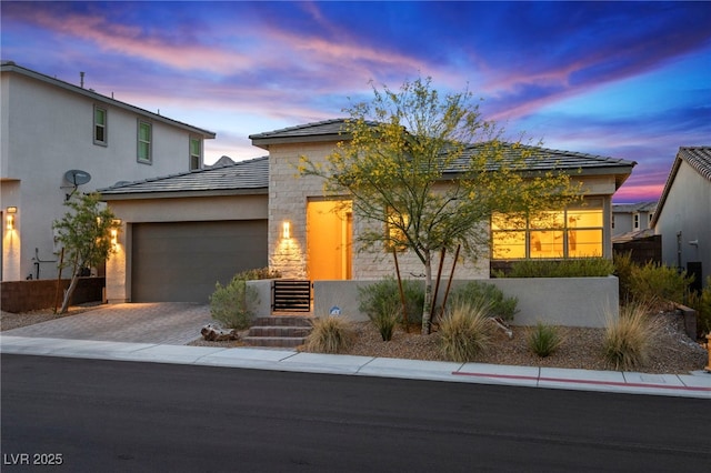 11672 Barga Ct, Las Vegas, NV 89138 - view of front of house featuring a garage, driveway, stucco siding, and stone siding