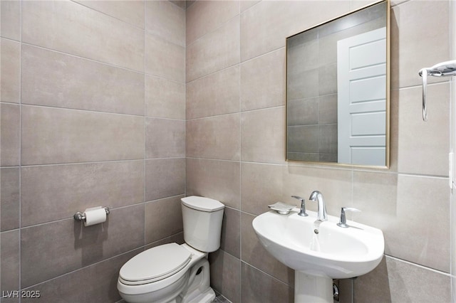 11672 Barga Ct, Las Vegas, NV 89138 - half bathroom featuring tile walls, toilet, and a sink