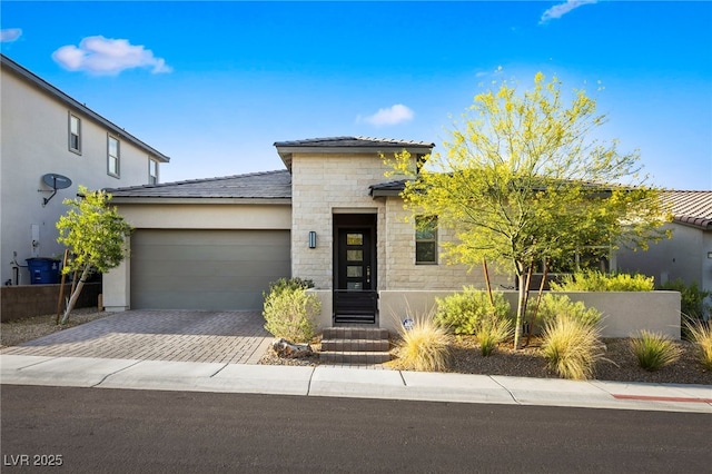 11672 Barga Ct, Las Vegas, NV 89138 - view of front facade with stone siding, an attached garage, decorative driveway, and stucco siding