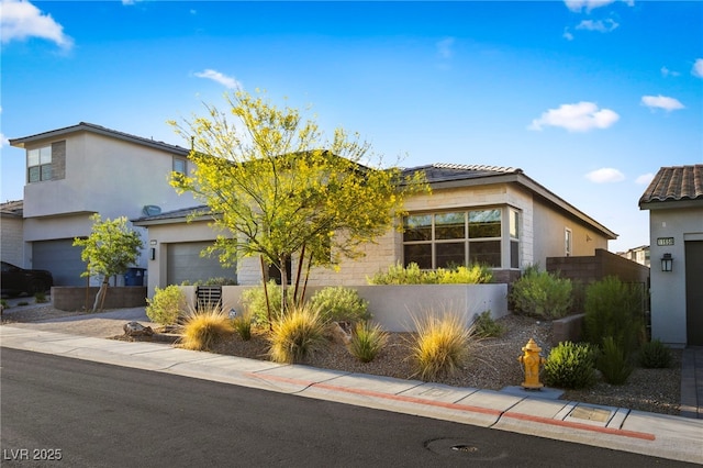 11672 Barga Ct, Las Vegas, NV 89138 - view of front facade with an attached garage, stucco siding, and driveway