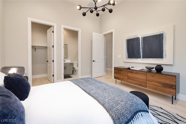 10781 Agate Cliffs Ave, Las Vegas, NV 89135 - bedroom featuring a chandelier, a walk in closet, baseboards, ensuite bathroom, and a closet