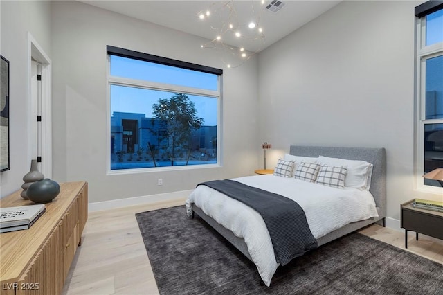 10781 Agate Cliffs Ave, Las Vegas, NV 89135 - bedroom with light wood finished floors, a chandelier, and baseboards