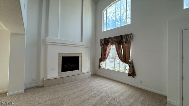10066 Golden Bluff Ave, Las Vegas, NV 89148 - unfurnished living room featuring carpet flooring, baseboards, healthy amount of natural light, and a high ceiling