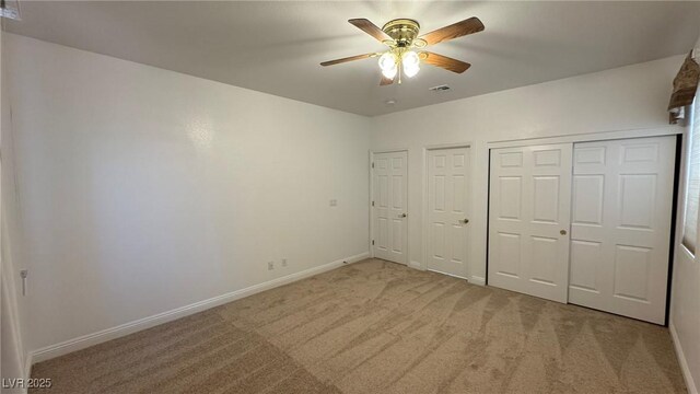 10066 Golden Bluff Ave, Las Vegas, NV 89148 - unfurnished bedroom featuring light colored carpet, baseboards, multiple closets, and ceiling fan