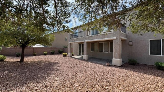 10066 Golden Bluff Ave, Las Vegas, NV 89148 - rear view of house featuring a balcony, a fenced backyard, stucco siding, and a patio area
