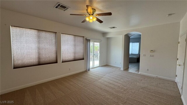 10066 Golden Bluff Ave, Las Vegas, NV 89148 - empty room featuring a ceiling fan, arched walkways, light colored carpet, baseboards, and a smoke detector