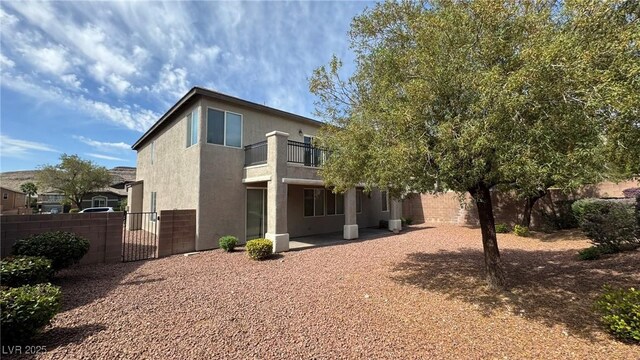 10066 Golden Bluff Ave, Las Vegas, NV 89148 - rear view of house featuring a balcony, a gate, stucco siding, and a patio area