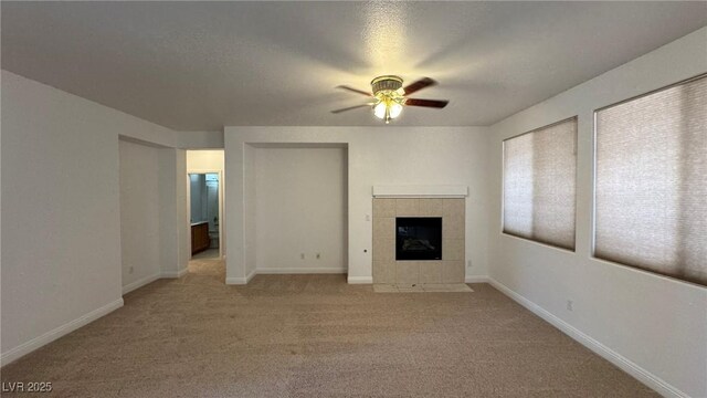 10066 Golden Bluff Ave, Las Vegas, NV 89148 - unfurnished living room featuring ceiling fan, a tile fireplace, light colored carpet, and baseboards