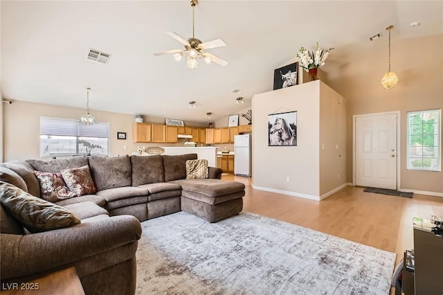 3539 Barrel Bronco Ct, North Las Vegas, NV 89032 - living area featuring light wood finished floors, a ceiling fan, a chandelier, high vaulted ceiling, and baseboards