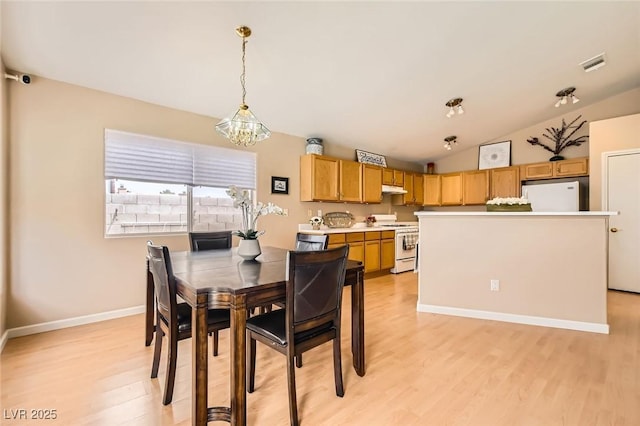 3539 Barrel Bronco Ct, North Las Vegas, NV 89032 - dining room featuring light wood-style flooring, a chandelier, vaulted ceiling, and baseboards