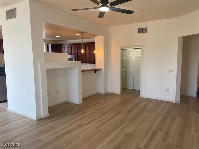 15 E Agate Ave Unit 202, Las Vegas, NV 89123 - unfurnished living room with a ceiling fan, light wood-style floors, and baseboards