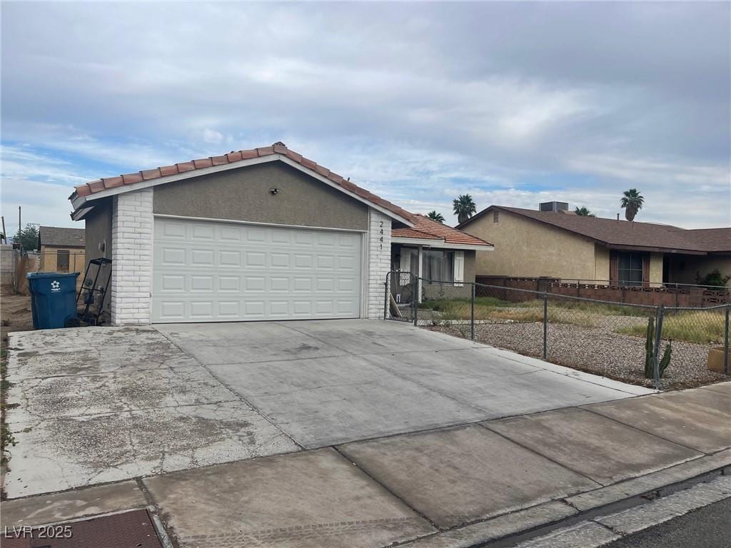 2441 Oak Glen Way, Las Vegas, NV 89115 - ranch-style house featuring driveway, brick siding, a tile roof, and stucco siding