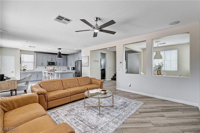 4308 Desert Haven Ave, North Las Vegas, NV 89085 - living room with a ceiling fan, baseboards, and light wood finished floors