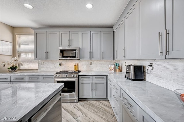 4308 Desert Haven Ave, North Las Vegas, NV 89085 - kitchen featuring appliances with stainless steel finishes, gray cabinets, light stone counters, a textured ceiling, and recessed lighting