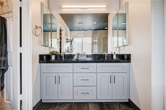 4308 Desert Haven Ave, North Las Vegas, NV 89085 - bathroom with double vanity, a shower, baseboards, and a textured wall