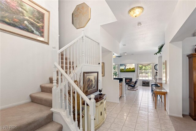 5104 Burr Oak Dr, Las Vegas, NV 89130 - stairway featuring a lit fireplace, tile patterned floors, and baseboards
