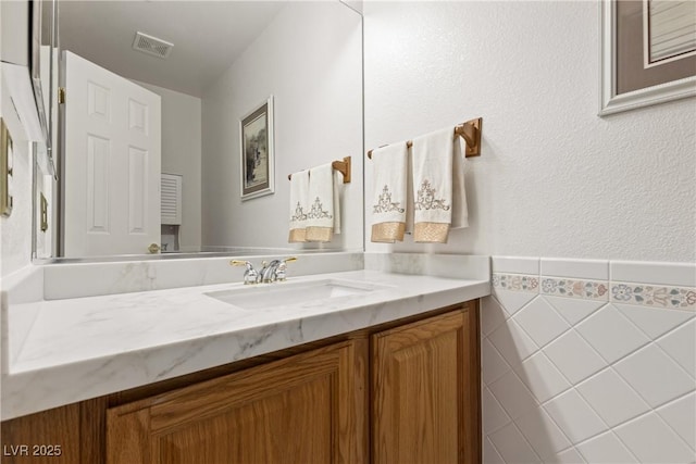 5104 Burr Oak Dr, Las Vegas, NV 89130 - bathroom with vanity, tile walls, and wainscoting