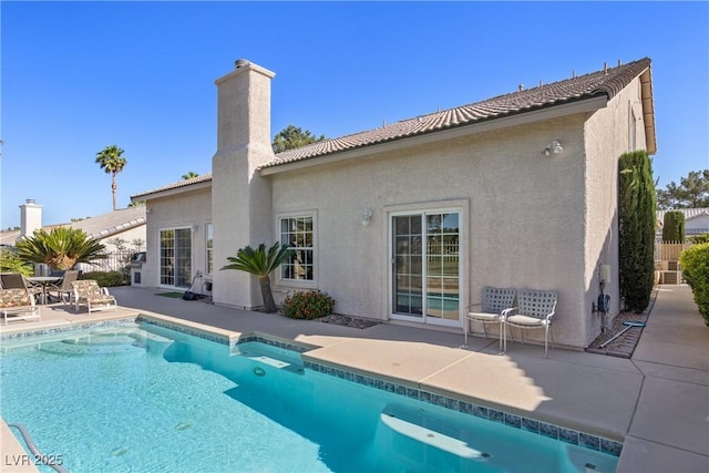 5104 Burr Oak Dr, Las Vegas, NV 89130 - back of house with a chimney, a patio, stucco siding, an outdoor pool, and a tile roof