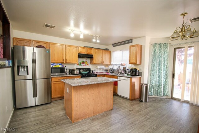 6520 Blooming Sun Ct, Las Vegas, NV 89142 - kitchen featuring stainless steel appliances, under cabinet range hood, a chandelier, light wood finished floors, and a kitchen island