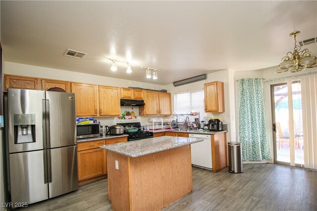 6520 Blooming Sun Ct, Las Vegas, NV 89142 - kitchen featuring stainless steel appliances, under cabinet range hood, a center island, a sink, and a chandelier