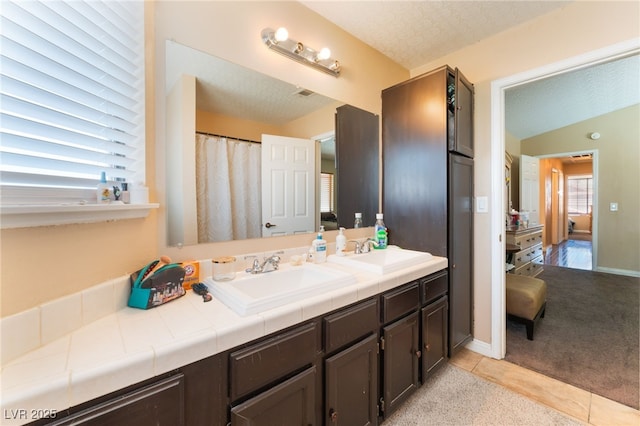 6529 Hartwood Rd, Las Vegas, NV 89108 - bathroom featuring double vanity, tile patterned floors, a textured ceiling, and baseboards