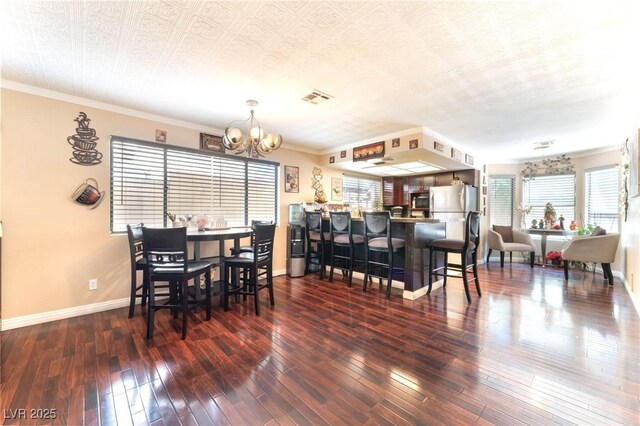 6529 Hartwood Rd, Las Vegas, NV 89108 - dining space featuring a chandelier, baseboards, hardwood / wood-style floors, and ornamental molding