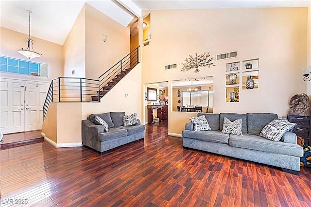 6529 Hartwood Rd, Las Vegas, NV 89108 - living area with stairway, high vaulted ceiling, wood finished floors, baseboards, and a chandelier