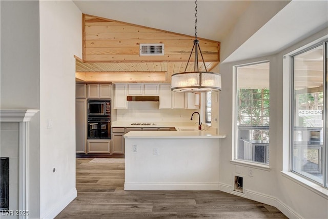 7417 Radville Dr, Las Vegas, NV 89129 - kitchen with black appliances, a sink, vaulted ceiling, wood finished floors, and pendant lighting