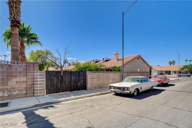 7417 Radville Dr, Las Vegas, NV 89129 - view of asphalt road featuring sidewalks, street lighting, and curbs