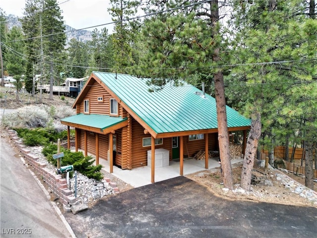 401 Alpine Way, Las Vegas, NV 89124 - view of front of house with a standing seam roof, log exterior, metal roof, and asphalt driveway