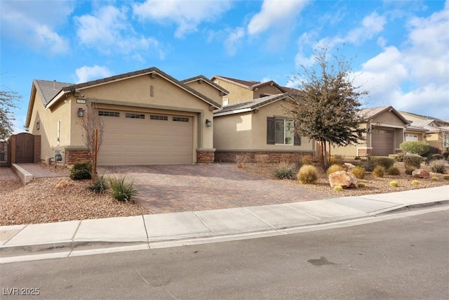7115 Calvert Cliffs St, North Las Vegas, NV 89084 - ranch-style house featuring stucco siding, decorative driveway, an attached garage, stone siding, and a gate