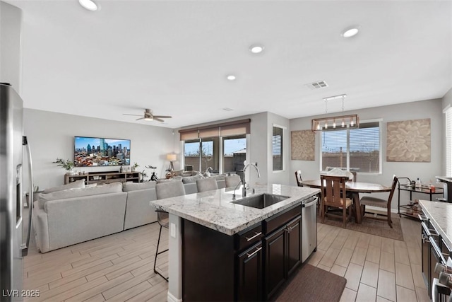 7115 Calvert Cliffs St, North Las Vegas, NV 89084 - kitchen with a sink, stainless steel appliances, wood tiled floors, ceiling fan, and a breakfast bar area
