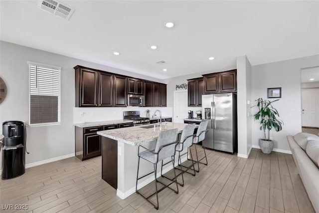 7115 Calvert Cliffs St, North Las Vegas, NV 89084 - kitchen with stainless steel appliances, a sink, light wood finished floors, dark brown cabinets, and recessed lighting
