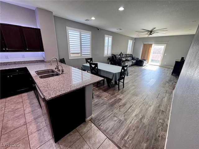 7035 Thistle Ridge St, Las Vegas, NV 89166 - kitchen featuring a sink, a ceiling fan, a textured ceiling, light stone counters, and a peninsula
