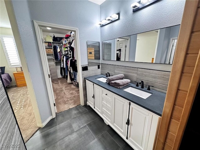 7035 Thistle Ridge St, Las Vegas, NV 89166 - bathroom with double vanity, a textured wall, and a walk in closet