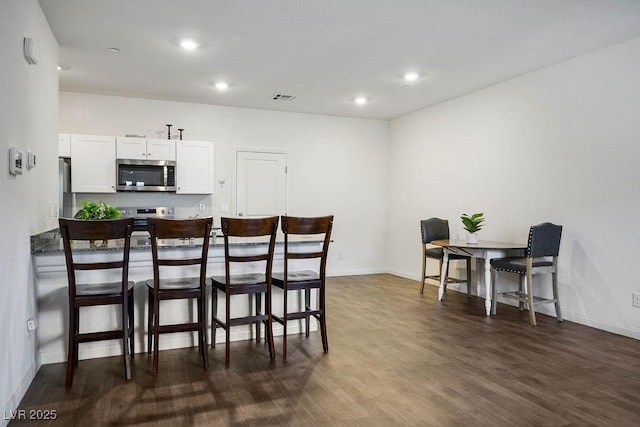 532 Clearsable Ave, Henderson, NV 89044 - kitchen featuring appliances with stainless steel finishes, a kitchen bar, dark wood-style flooring, white cabinetry, and baseboards