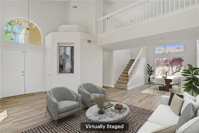 7813 Paper Flower Ct, Las Vegas, NV 89128 - living area with a chandelier, a towering ceiling, stairs, wood finished floors, and baseboards