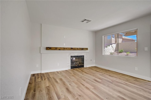 7813 Paper Flower Ct, Las Vegas, NV 89128 - unfurnished living room with wood finished floors, a glass covered fireplace, and baseboards