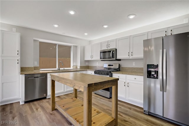 7813 Paper Flower Ct, Las Vegas, NV 89128 - kitchen with appliances with stainless steel finishes, a sink, white cabinets, light wood finished floors, and recessed lighting