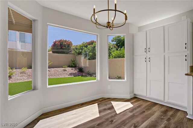 7813 Paper Flower Ct, Las Vegas, NV 89128 - unfurnished dining area featuring a chandelier, wood finished floors, and baseboards