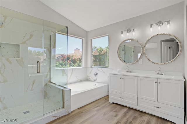 7813 Paper Flower Ct, Las Vegas, NV 89128 - full bathroom with lofted ceiling, a bath, a marble finish shower, double vanity, and wood finished floors