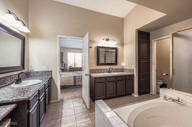 310 Pissarro Pl, Henderson, NV 89074 - ensuite bathroom featuring two vanities, tiled tub, toilet, tile patterned flooring, and baseboards