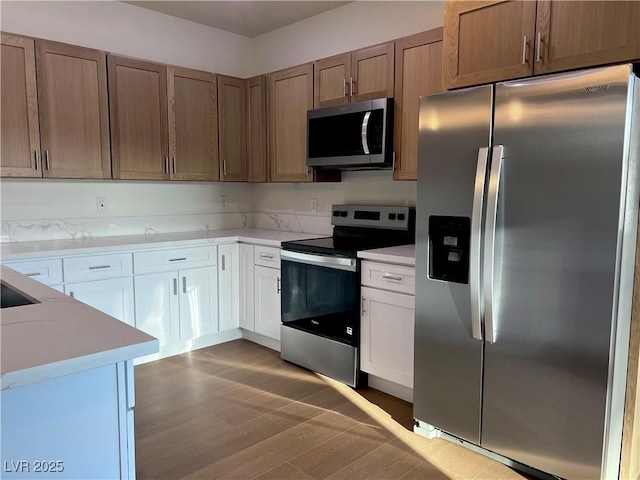 1905 Harvard St, North Las Vegas, NV 89030 - kitchen with stainless steel appliances, wood finished floors, light countertops, and white cabinets