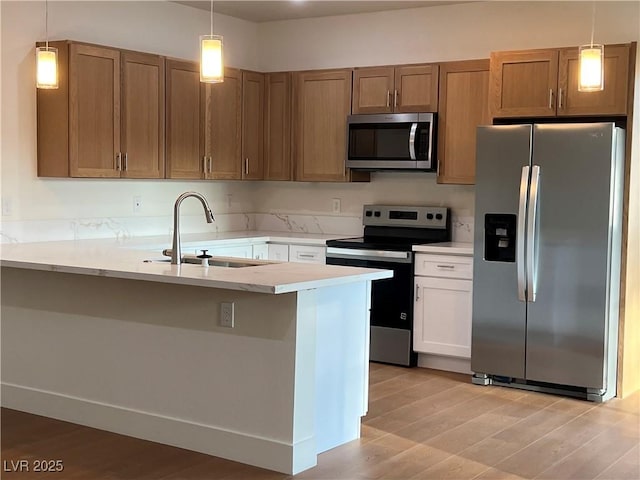 1905 Harvard St, North Las Vegas, NV 89030 - kitchen with appliances with stainless steel finishes, a sink, light wood finished floors, light countertops, and pendant lighting