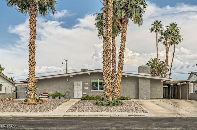 5217 Champions Ave, Las Vegas, NV 89142 - mid-century modern home with stucco siding, concrete driveway, and an attached carport
