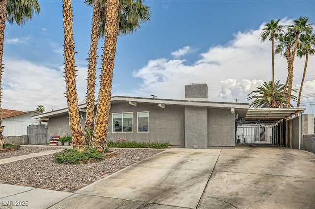 5217 Champions Ave, Las Vegas, NV 89142 - mid-century home with stucco siding, driveway, a carport, and a chimney