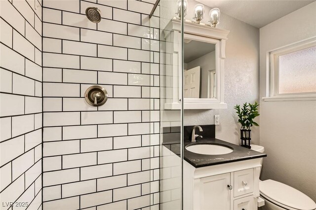 5217 Champions Ave, Las Vegas, NV 89142 - full bath with a tile shower, vanity, toilet, and a textured wall