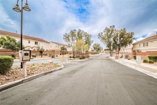 4833 Straight Flush Dr Unit 103, Las Vegas, NV 89122 - view of asphalt road with a residential view, sidewalks, curbs, and a gated entry